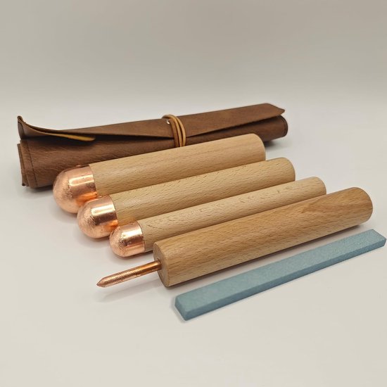 Ensemble de quatre outils de taille de pierre : un rouleau, trois manches ronds en bois avec embouts en cuivre et une pierre à aiguiser.