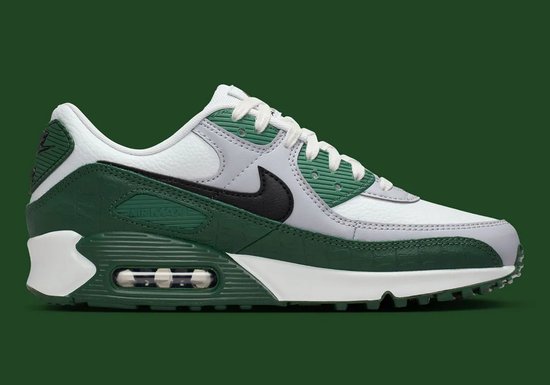 Vue latérale d'une sneaker Nike Air Max 90 blanche avec des empiècements en cuir vert croco, une semelle blanche et un Swoosh noir.