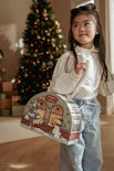 Meisje met lange zwarte haren, draagt een witte blouse en spijkerbroek, vasthoudend aan een treinstation adventskalender.