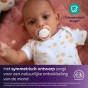 Baby met een witte Philips Avent fopspeen. Orthodontisch ontwerp voor natuurlijke ontwikkeling van de mond. Gemaakt van 80% plantaardige materialen.