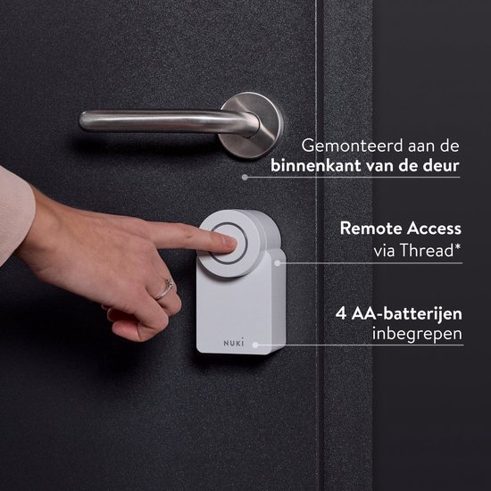 Witte Nuki-deurslot aan de binnenkant van een deur, met de tekst "Remote Access" en "4 AA-batterijen inbegrepen".