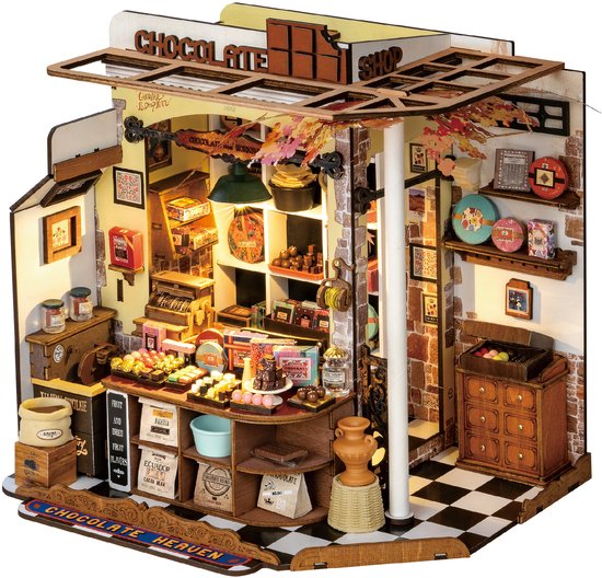 Gedetailleerde miniatuur "CHOCOLATE SHOP" met laden, toonbank met chocolade, en poster "CHOCOLATE HEAVEN".