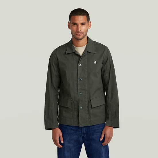 Man met donkergroen G-Star jack, beige T-shirt en jeans.