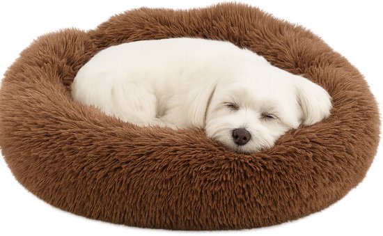 Chien blanc dormant dans un panier rond, marron et pelucheux sur fond noir.