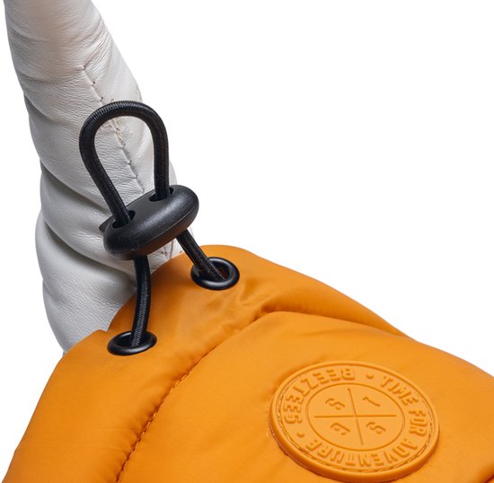 Sluiting van een oranje hondenjas met touwtje en stopper. Een deel van een witte hoorn is zichtbaar.