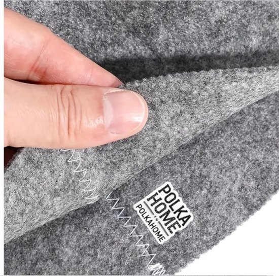 Close-up van grijs vilt met geborduurde "PolkaHome" label en stiksels.