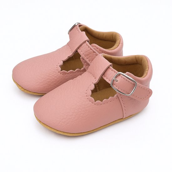 Roze babyschoentjes met gesp en geschulpte randen.