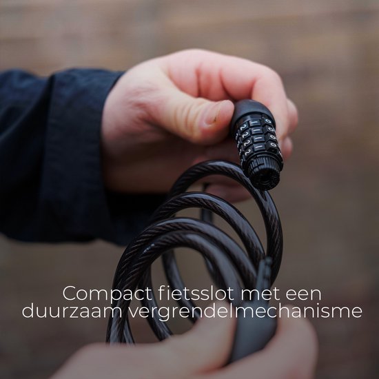 Mains tenant un câble de vélo noir avec serrure à combinaison de 4 chiffres.