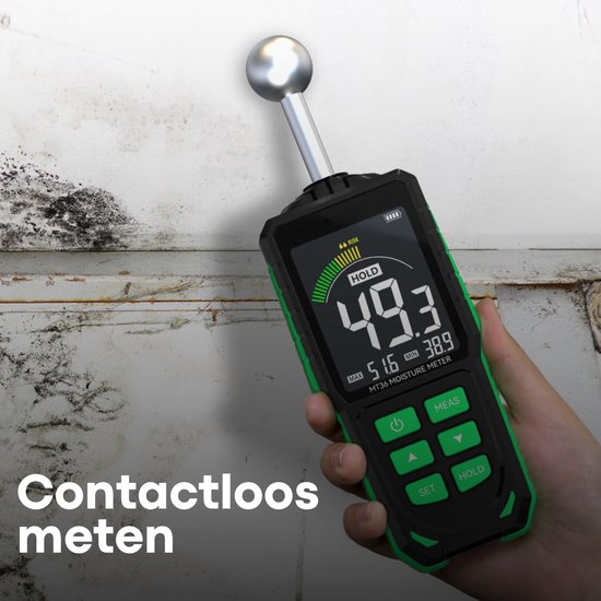 Membeli vochtmeter met een hand, meet contactloos een vochtige muur.
