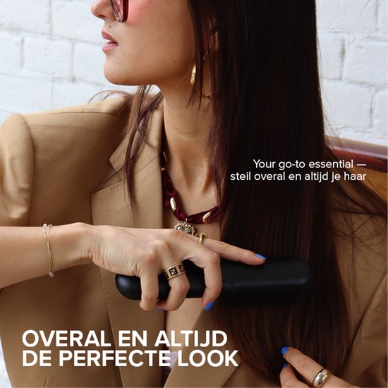Vrouw met bruine blazer stylet haar met zwarte stijltangborstel.