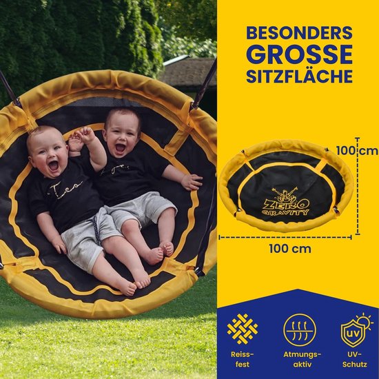 Grote ronde schommel met zwarte en gele stof, met twee lachende baby's erop. Afmeting 100x100cm.
