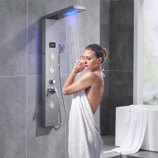 Vrouw met handdoek onder een douchepaneel met blauwe LED-verlichting.