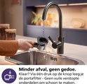 Schoonmaken van de portafilter van de Philips Baristina onder de kraan.