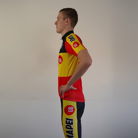 Zijaanzicht van jonge man in Mapei wielershirt en broek, geel, rood en zwart met logo's.