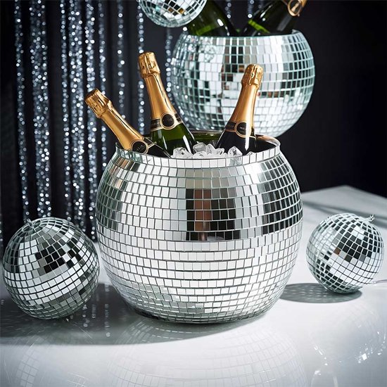 Zilveren discoball ijsemmer gevuld met champagneflessen en ijs, naast kleinere discoballen.