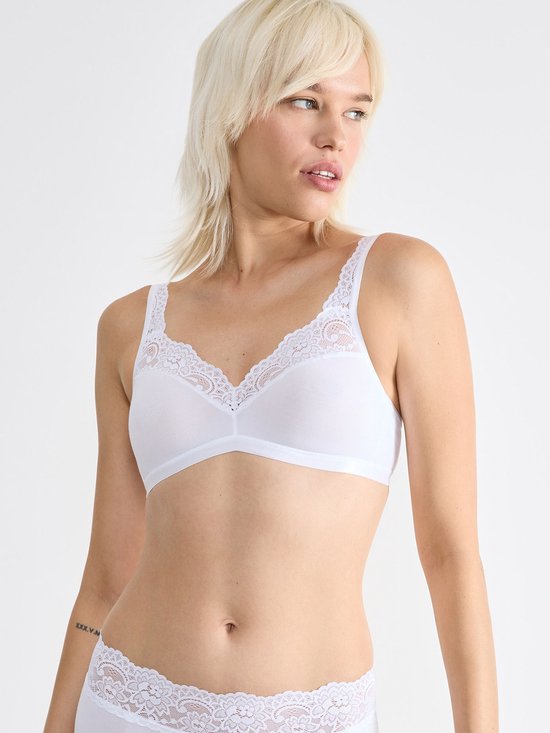 Wit kanten bralette met kanten afwerking bij de V-hals en schouderbandjes, gedragen door een blond model.