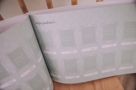 Open boek met sage groene pagina's voor 'mijn pasfoto's'. Elk met 12 vakken met camerabeeldjes en jaartallen.