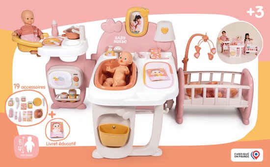 Roze en witte poppenverzorger met 19 accessoires. Bevat babypop, badje, commode met wasbak en wieg.