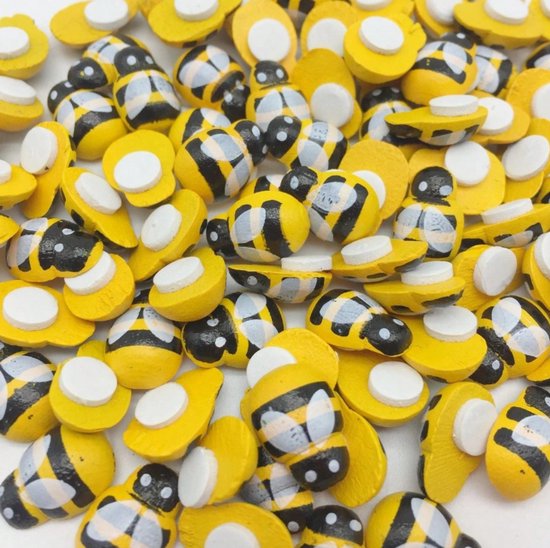 Een close-up van miniatuur houten bijtjes met gele en zwarte strepen en witte vleugeltjes.