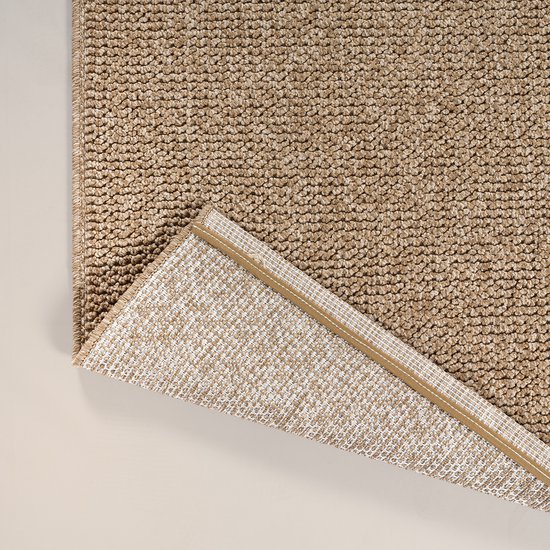 Un tapis brun à l'aspect jute, montrant le dessous blanc quadrillé.