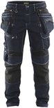 Donkerblauwe spijkerbroek met veel zakken, ritssluitingen en witte stiksels.
