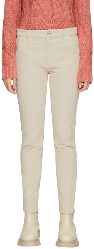 Crèmekleurige corduroy broek met een aansluitende pasvorm, gedragen door een model met een roze trui en beige laarsjes.