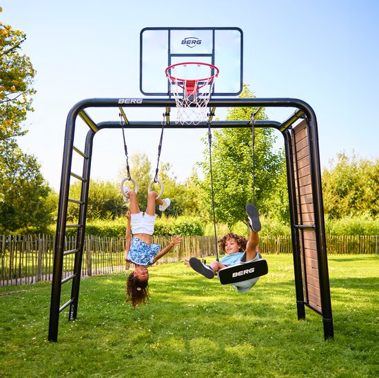Kinderen spelen op een zwart speeltoestel met schommels, ringen, een basket en een zijpaneel.