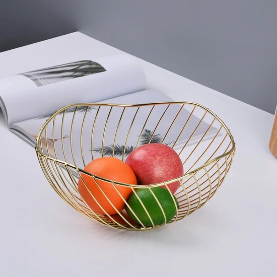 Gouden fruitschaal met verticale spijlen, gevuld met een sinaasappel, groene limoen en een rode appel.