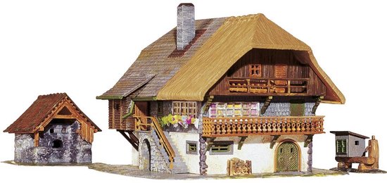 Een schaalmodel van een boerderij met rieten dak, stenen muur en houten details.