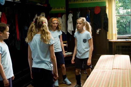 Meisjes in lichtblauwe sporttenues in een kleedkamer.