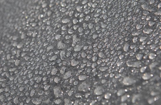 Gedetailleerde close-up van waterdruppels op een donkergrijs, geweven textiel.