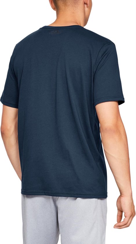 Donkerblauw sportshirt van Under Armour, gedragen door een man. Zwart logo op achterkant.