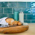Twee RETULP tumblers, één groen, één crème, met brood en een ei op een houten plank.