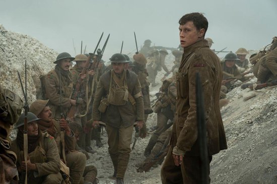 Soldaten in bruine uniformen staan in een loopgraaf. Eén soldaat kijkt angstig naar rechts.