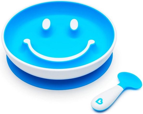 Blauw smiley bord met witte rand en een blauw-witte lepel op een blauwe ondergrond.
