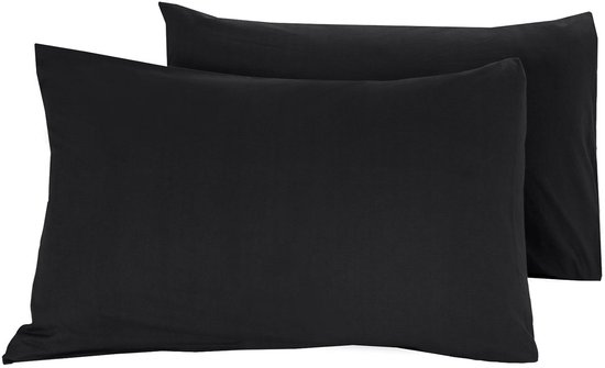 Twee zwarte kussenslopen op een wit bed.