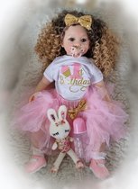 Reborn baby pop 'Maddie' - 60 cm - Meisje met lange, blonde krullen - Met romper, rok, schoenen, knuffel, speen en fles - Soft silicone - Levensechte babypop