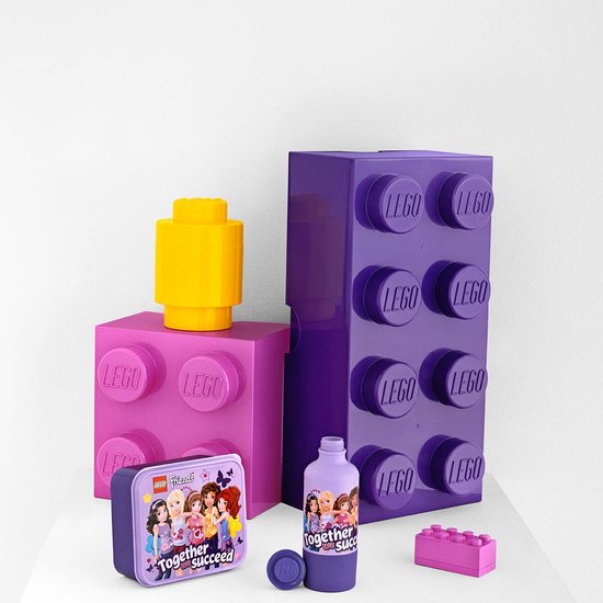 Gourde violette LEGO Friends avec bouchon dévissé, à côté d'une boîte à lunch LEGO et de boîtes de rangement en forme de LEGO.