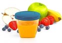 Gevuld bewaarbekertje met sinaasappelsap omringd door fruit: aardbeien, bosbessen, groene appel en banaan.