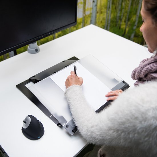 Vrouw met witte trui schrijft op een document dat op een documenthouder ligt.