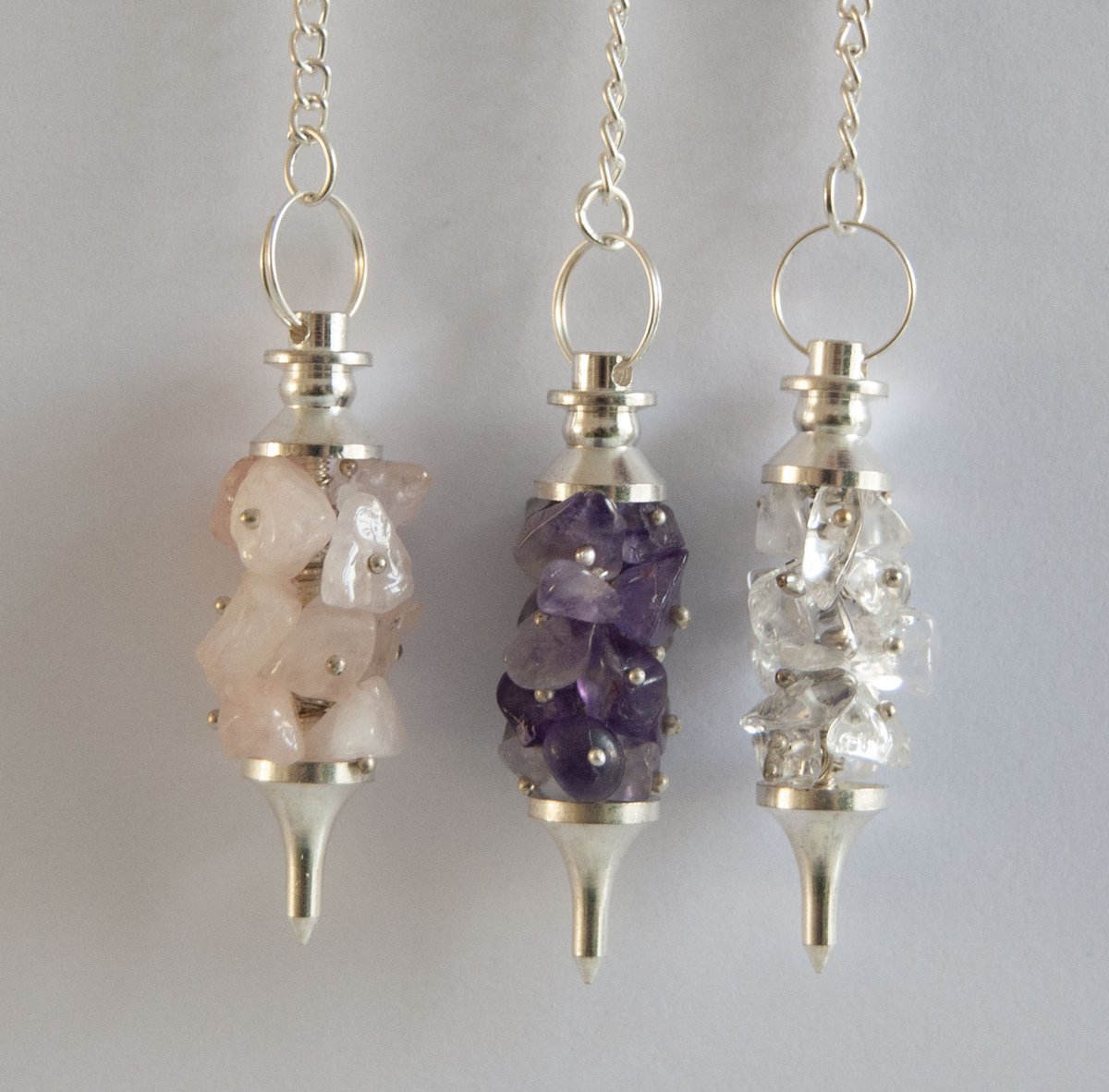 Gouden driehoek pendels. Bergkristal, amethist en rozenkwarts. Pendelen, Edelsteen.