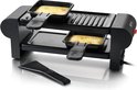 Zwarte raclette set met twee gesmolten kaas pannetjes, grillplaat en spatel.