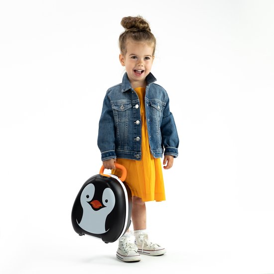 Een lachend meisje met een gele jurk en spijkerjasje draagt een pinguïn porta-potje met oranje handvat.