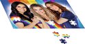 Drie vrouwen met regenboogjurken, deel van een puzzel. K3 logo boven.