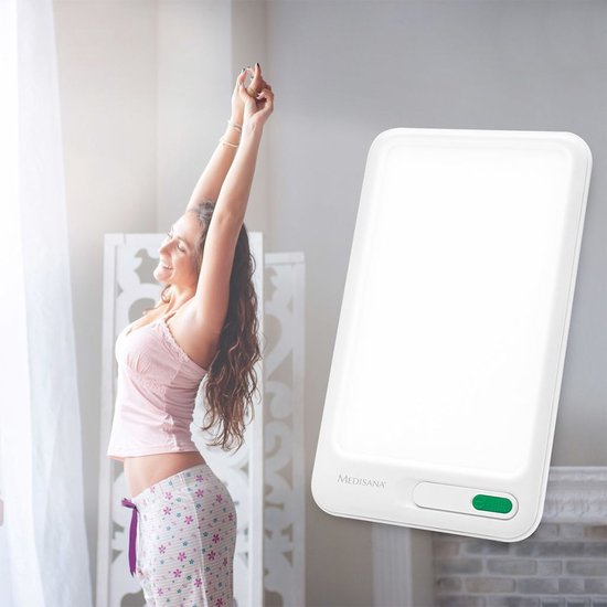 Vrouw rekt zich uit in het ochtendlicht naast een medisana daglichtlamp.