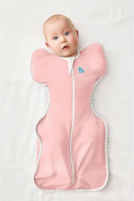 Baby met grote blauwe ogen in een roze Love to Dream™ Swaddle Up™ inbakerdoek, liggend op de rug.
