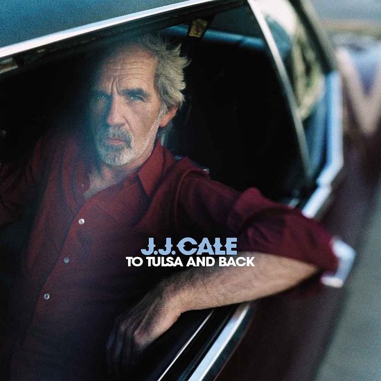 J.J. Cale met opdruk 'J.J. Cale To Tulsa and Back' op een wijnrode blouse in de auto.