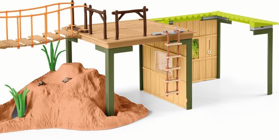 Speelgoed avonturenstation met een grot, hangbrug en een huisje op palen.