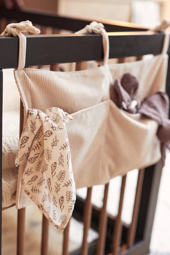 Lichtbeige corduroy boxopberger met bruine knuffels en een plantenprint doekje.