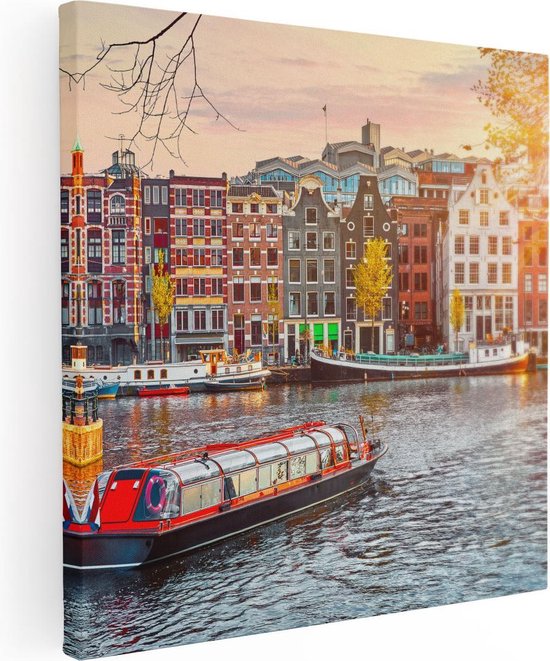 Canvas van een rode rondvaartboot op een gracht in Amsterdam, met kleurrijke huizen op de achtergrond bij zonsondergang.